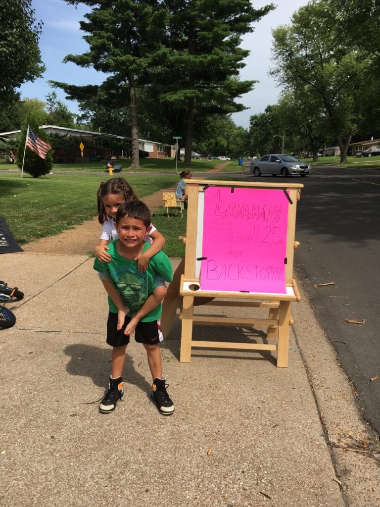 Roderick and Victoria having fun selling lemonade for BackStoppers